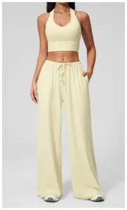 Detail of light yellow yoga set featuring halter neck top and high-waist drawstring pants