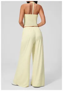 Detail view of pale yellow yoga set featuring a T-back strap top and wide-leg trousers