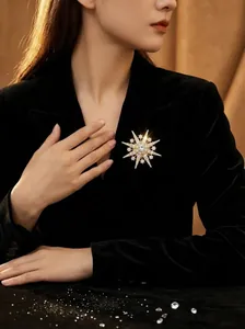 Sparkling snowflake brooch with gold-tone stars pinned on a black velvet blazer