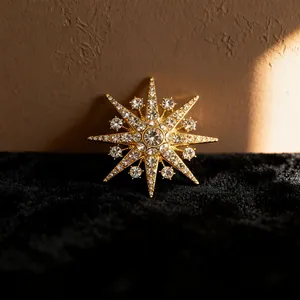 Detailed close-up of a sparkling gold starburst brooch with clear crystal inlay
