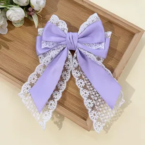 Detailed close-up of the vintage lace and purple satin layers on this elegant hair bow