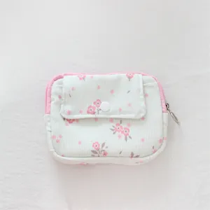 Detailed close-up of corduroy floral coin purse featuring a snap pocket and pink zipper