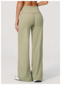 Détail d'un pantalon de yoga vert clair avec taille large repliée et coutures plates précises