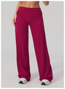 Détail de la taille haute repliée sur un pantalon de yoga large de couleur bordeaux