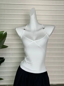 Dettaglio di canotta in maglia a coste bianca con scollo a V incrociato e spalline