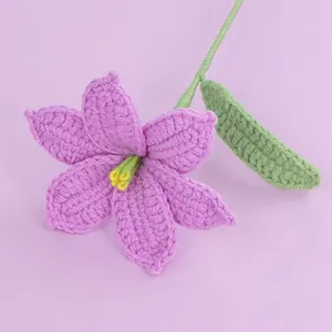 Handmade crochet pink lily flower with green stem on a light purple background