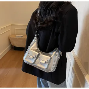 Detail of silver metallic hobo bag featuring cargo pockets and silver rivet studs