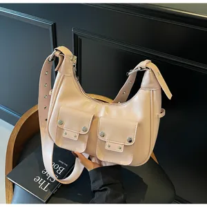 Detail view of pink biker style shoulder bag with silver rivets and dual front pockets
