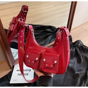 Detailed view of red moon-shaped shoulder bag with silver hardware and retro pockets