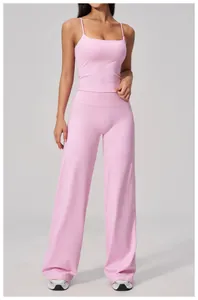 Gros plan sur la texture du tissu brossé rose clair du pantalon de yoga évasé