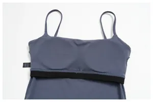 Détail du haut de sport bleu-gris montrant le tissu polyamide et la bande élastique
