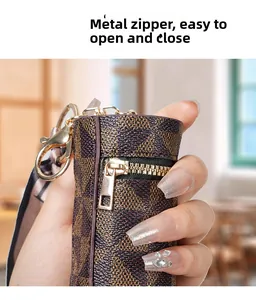 Dettaglio mini portamonete monogramma con zip dorata e nastro decorativo in seta
