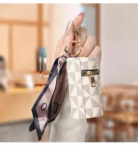 Dettaglio di un portamonete cilindrico a scacchi con decorazione in foulard di seta