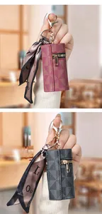 Dettaglio mini portamonete in pelle con motivo, zip dorata e sciarpa di seta decorativa