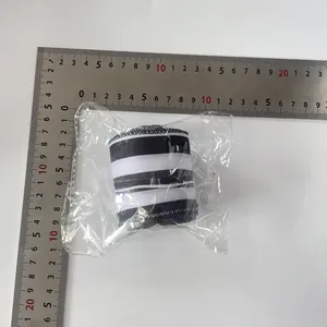 Close-up of 6cm black and white striped Christmas ribbon in clear packaging with a scale