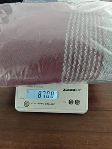 Dettaglio di un maglione in maglia a righe che mostra il peso di 870,8g su una bilancia