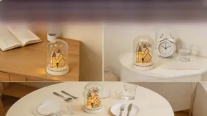 Macro shot of miniature wooden Christmas house with LED lights in a glass dome