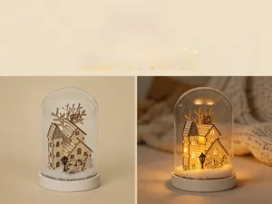 Close-up of wooden Christmas house with LED light inside a clear glass dome dome