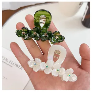 Detailed view of floral acetate hair claws with sparkling rhinestones and metal springs