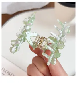 Close-up of three-petal floral acetate hair claw clip with green and white marble texture