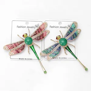 Détail de broches libellules avec ailes émaillées dégradées et pierres incrustées