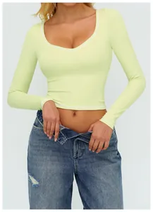 Dettaglio del crop top verde lime a maniche lunghe con cuciture a contrasto bianche