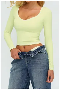 Dettaglio del crop top yoga verde chiaro con cuciture bianche a contrasto e scollo rotondo