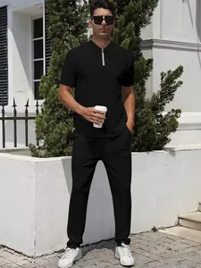 Detail of men's casual tracksuit featuring a black zippered polo shirt and trousers