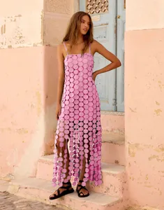 Detail of pink laser-cut lace maxi dress with geometric circular patterns and fringe