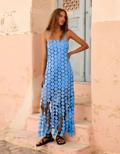 Detail of light blue hollow-out maxi dress with circular patchwork and tassel hem