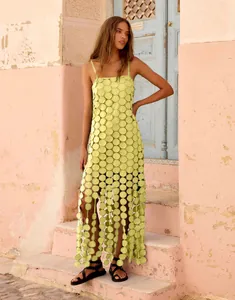 Detailed view of lime green hollow-out strap dress with circular sequin texture
