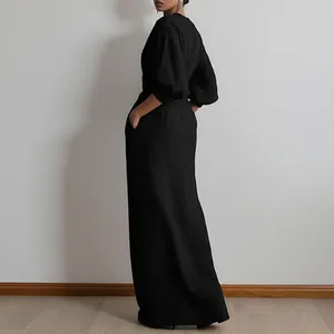 Elegante abito lungo nero con scollo a V, maniche a sbuffo e pratiche tasche laterali