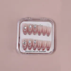 Detail of pink gradient press-on nails with silver glitter, rhinestones, and 3D bows