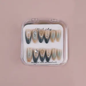 Detail of almond press-on nails with green french gradient and silver star charms