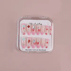 Detail of 12pcs almond press-on nails set with rhinestones and floral heart patterns