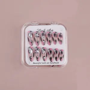 Detailed view of handmade pink and black almond press-on nails with silver rhinestones