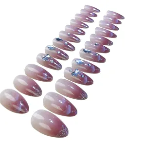Pink and purple gradient press-on nails with sparkling glitter and 3D rhinestone bows