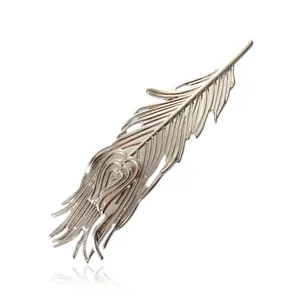 Macro detail of silver phoenix feather hair clip with heart-shaped metal engraving