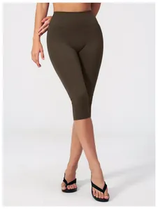 Close-up of olive brown high-waisted capri yoga pants with seamless athletic fabric