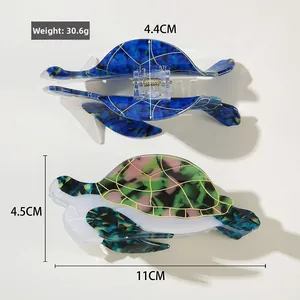Detail of sea turtle hair claws showing 11cm length and colorful acetate texture