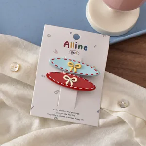 Detail of colorful oval hair clips with bows and rhinestones on display card