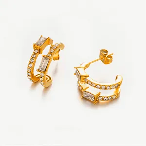 Detail of C-shaped gold-plated stainless steel earrings with sparkling zircon stones