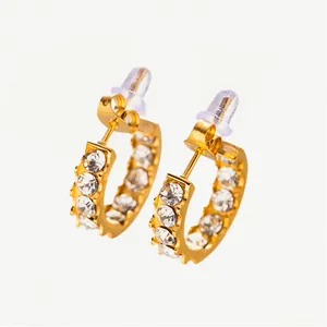 Detailed view of gold C-shaped hoop earrings with sparkling rhinestones and butterfly backs