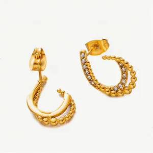 Close-up of gold-plated C-shaped earrings featuring micro beads and zircon inlays