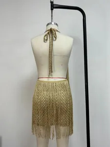 Détail d'un ensemble robe à franges métalliques dorées avec texture brillante et dos nu