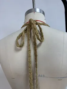 Détail de liens de cou crochet kaki avec nœud à franges sur le dos d'un mannequin femme