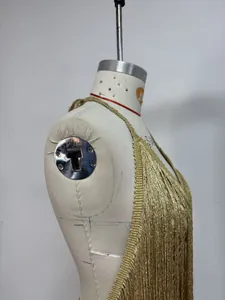 Vue détaillée d'une robe dos nu à franges dorées avec des détails de texture fluide