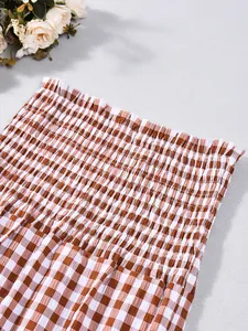 Detailaufnahme der Smocking-Verarbeitung auf braunem Gingham-Zweiteiler-Stoff