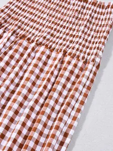 Detailansicht des braun-weißen Gingham-Musters mit elastischer gesmokter Stoffstruktur