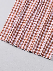 Detailaufnahme von braun-weiß kariertem Stoff mit Plisseestruktur für Damenbekleidung